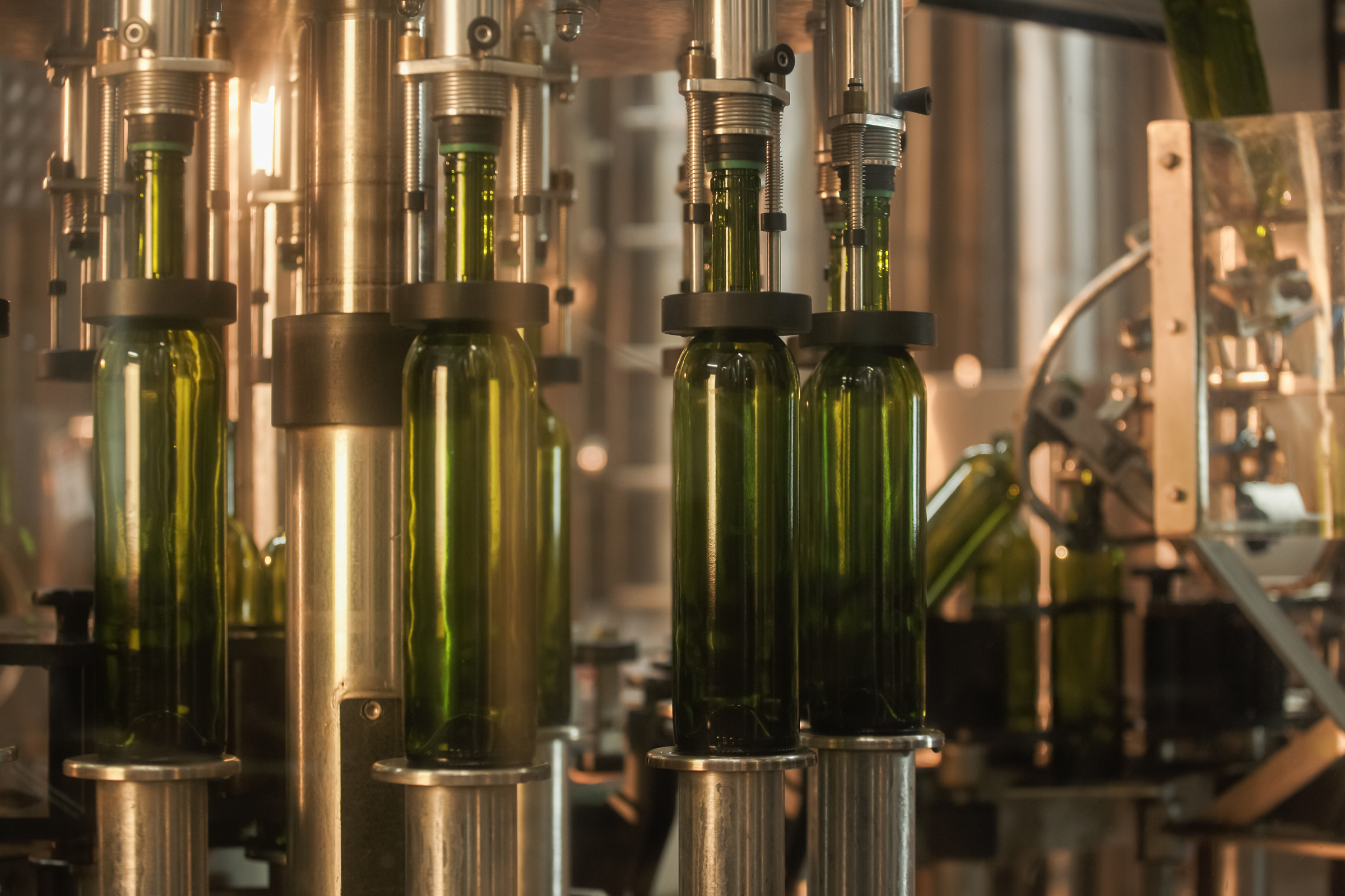 Industrielle Weinabfüllmaschine aus rostfreiem Stahl, mit grünen Weinflaschen